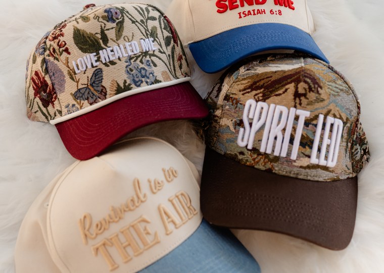 A stack of faith-based branded caps