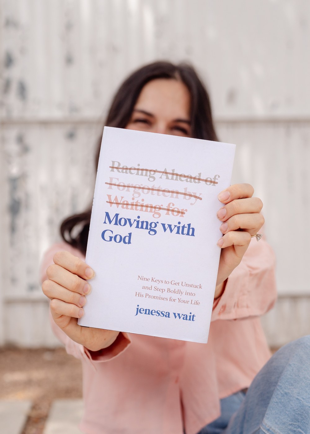 Jenessa Wait holding a copy of the book Moving with God